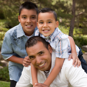 2 boys hugging shoulders of man